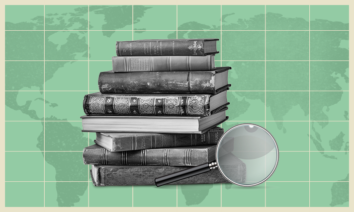 A magnifying glass in front of a stack of books used in education research