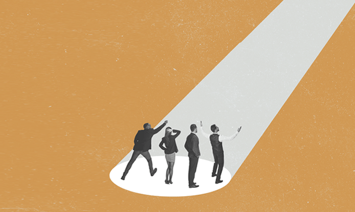 Four people standing in a spotlight looking up against a gold background.