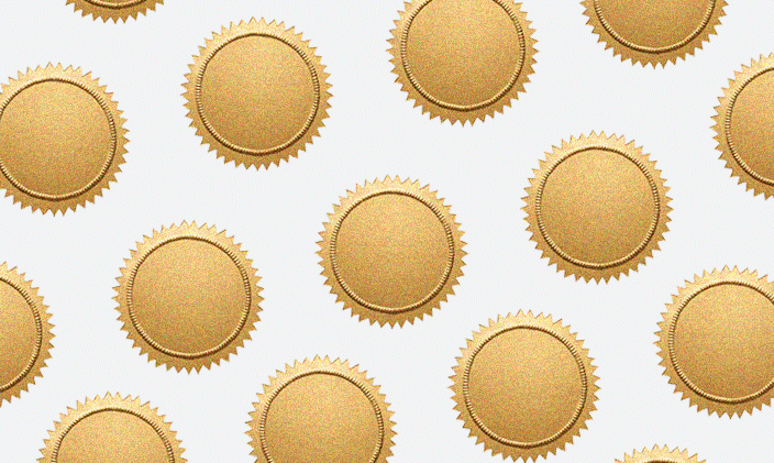 Gold medals fill the frame against a white background. 