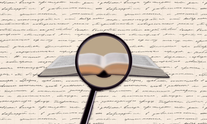 A magnifying glass in front of an open book focused on the center of the book.